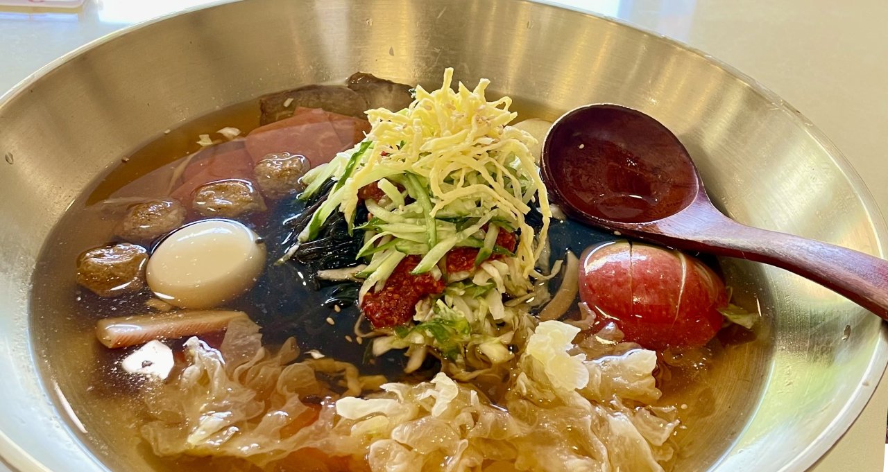 บะหมี่เย็นเหยียนจี๋พร้อมเครื่องมากมายภายในชามขนาดใหญ่และช้อนไม้