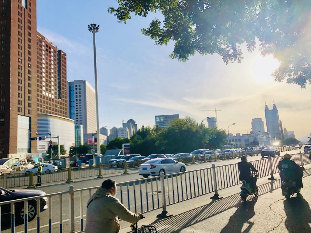 บรรยากาศภายในเมืองโฮฮอตมีรถเก๋งบนถนนริมทางมีคนจีนขี่จักรยานให้เช่า